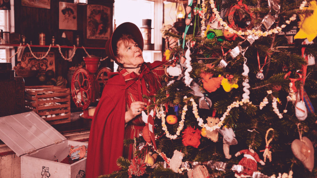 A traditional Ulster lady dressing her Christmas tree with ornaments.
