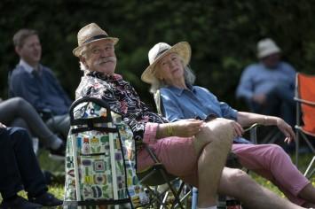 A couple relaxing on camping chairs and wearing sun hats