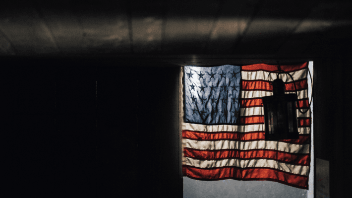 A darkly lit room with the American flag