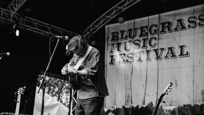 A man playing the guitar on stage at Bluegrass Omagh 2022