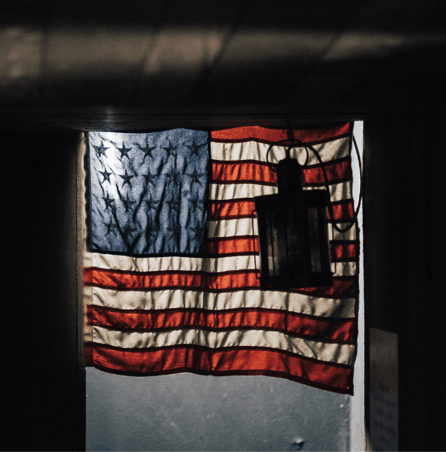 American Flag in a door way with old lantern in front