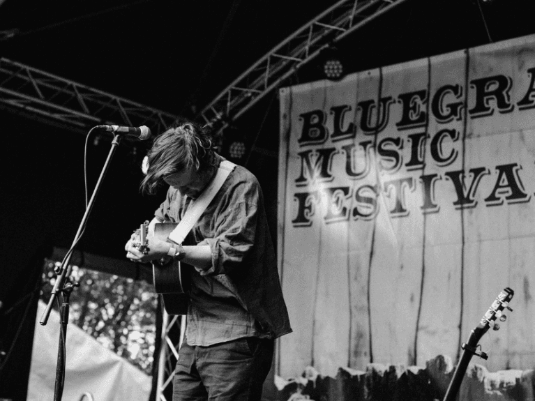 A man playing the guitar on stage at Bluegrass Omagh 2022
